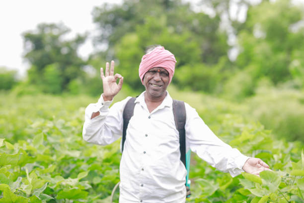 indian farmer holding spray pump in hand , farm worker